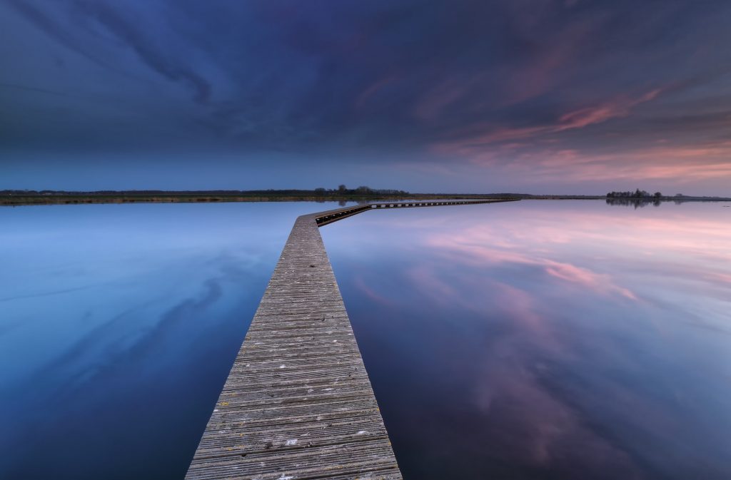 wooden walkpath on water at dawn